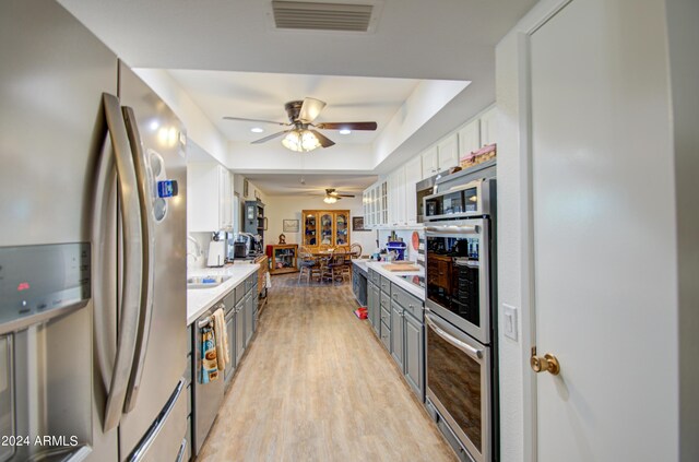 kitchen featuring white cabinets, gray cabinetry, light hardwood / wood-style flooring, appliances with stainless steel finishes, and ceiling fan