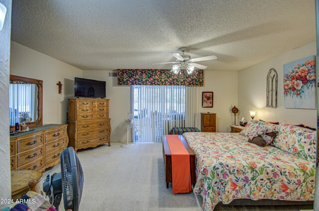 bedroom with a textured ceiling, carpet, and ceiling fan