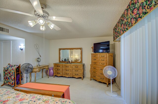 bedroom featuring ceiling fan, carpet floors, and a textured ceiling