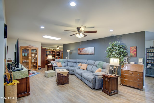 living room with light hardwood / wood-style flooring and ceiling fan