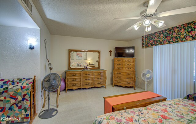 bedroom featuring ceiling fan, light colored carpet, and a textured ceiling