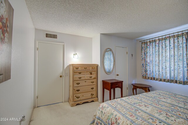 carpeted bedroom featuring a textured ceiling