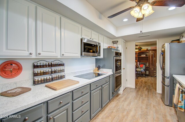 kitchen featuring ceiling fan, gray cabinetry, white cabinetry, appliances with stainless steel finishes, and light wood-type flooring