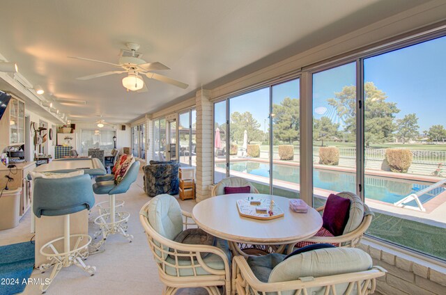 sunroom / solarium featuring ceiling fan