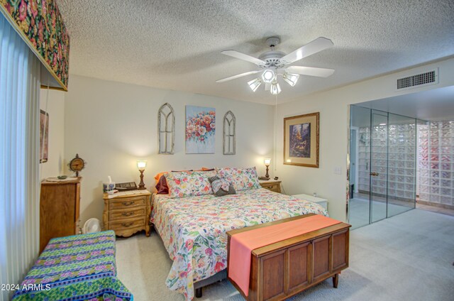 carpeted bedroom with ceiling fan, access to exterior, and a textured ceiling