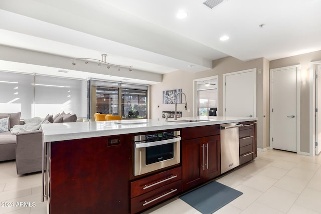 kitchen with sink, stainless steel appliances, and an island with sink