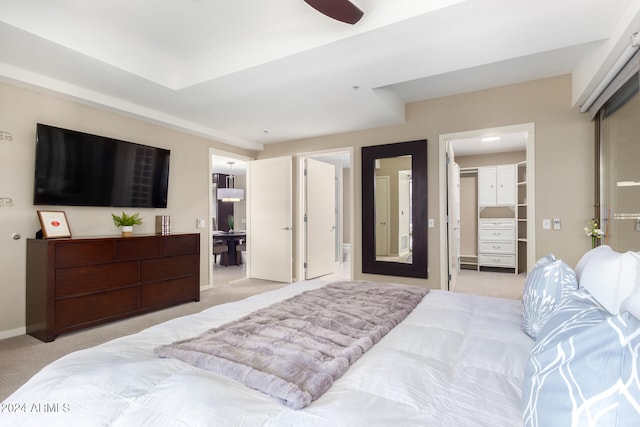 carpeted bedroom with ceiling fan, a spacious closet, and connected bathroom