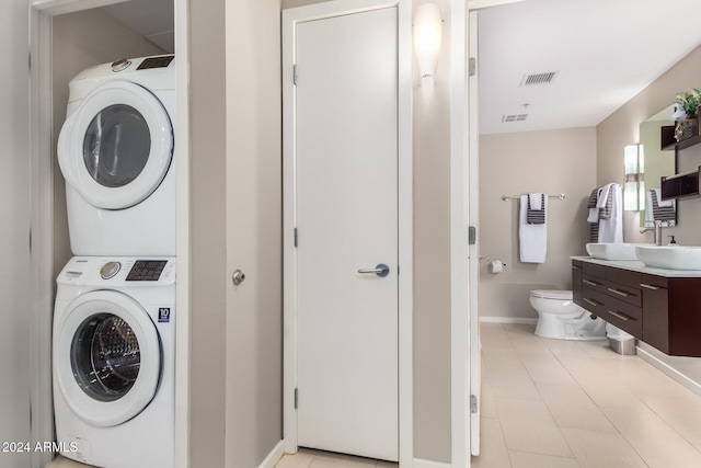 laundry room with sink and stacked washer / dryer