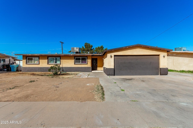 single story home with a garage and central AC unit