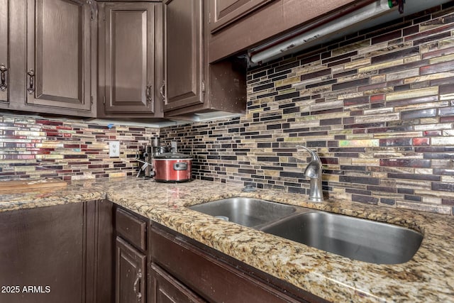 kitchen featuring sink, dark brown cabinetry, and decorative backsplash