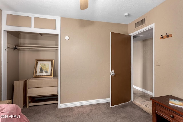 bedroom featuring a textured ceiling, a closet, ceiling fan, and carpet