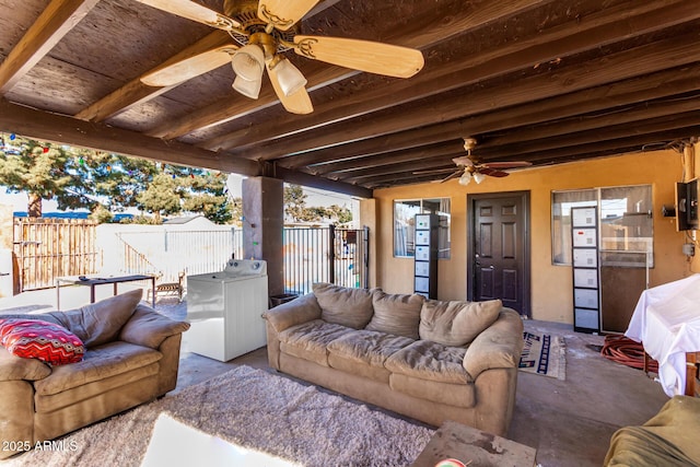 interior space with beamed ceiling, ceiling fan, and washer / dryer