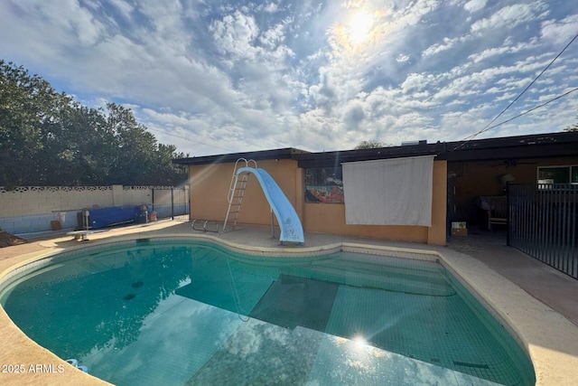 view of swimming pool with a patio and a water slide