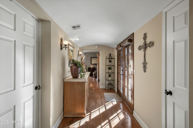 corridor with lofted ceiling and wood-type flooring