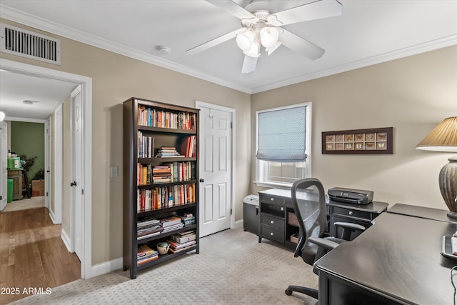 home office with light carpet, crown molding, and ceiling fan