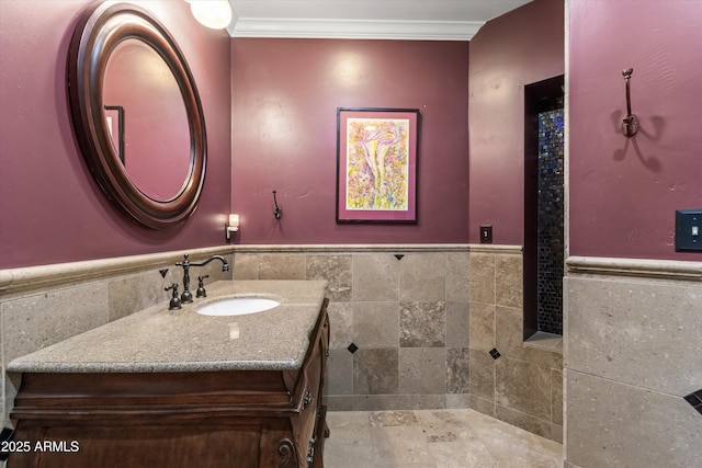 bathroom featuring crown molding, vanity, and tile walls