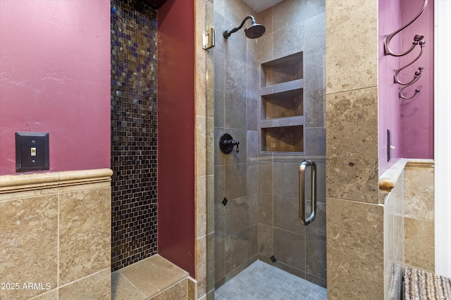 bathroom with a shower with door and tile walls