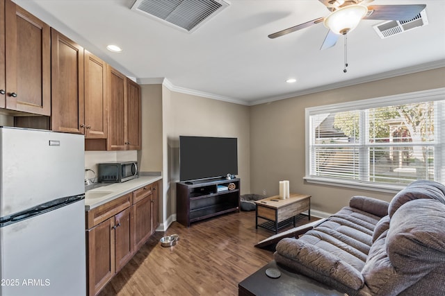 living room featuring sink, crown molding, wood-type flooring, and ceiling fan