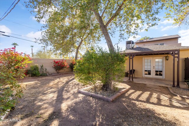 view of yard with french doors, a patio area, and central air condition unit