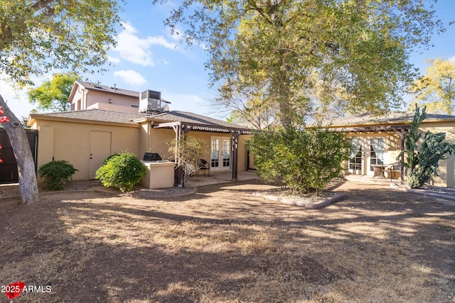 rear view of house featuring french doors, central AC, and a patio area