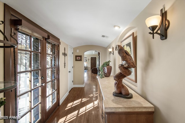 hallway featuring dark hardwood / wood-style flooring and vaulted ceiling