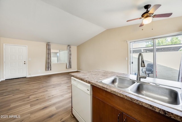 kitchen featuring vaulted ceiling, sink, dishwasher, ceiling fan, and hardwood / wood-style flooring