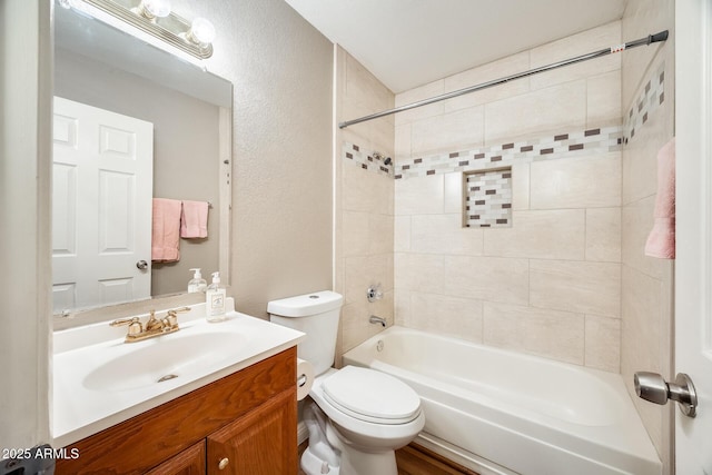 full bathroom featuring toilet, vanity, and tiled shower / bath