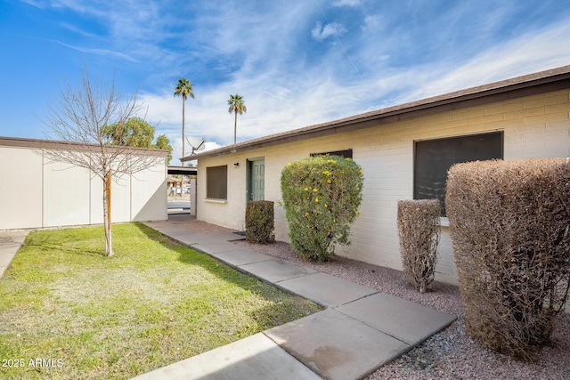 view of side of home with a yard