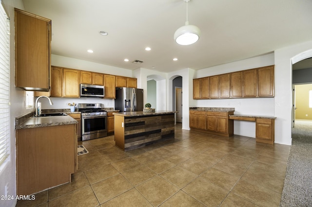 kitchen featuring sink, hanging light fixtures, tile patterned flooring, a kitchen island, and stainless steel appliances