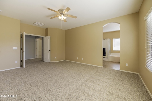 carpeted spare room featuring ceiling fan