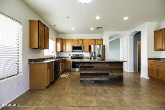 kitchen featuring a center island, tile patterned flooring, stainless steel appliances, and sink