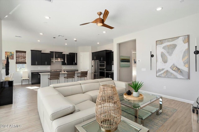 living room featuring ceiling fan and light wood-type flooring