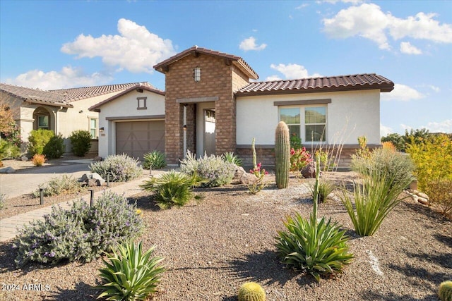 mediterranean / spanish-style home with a garage