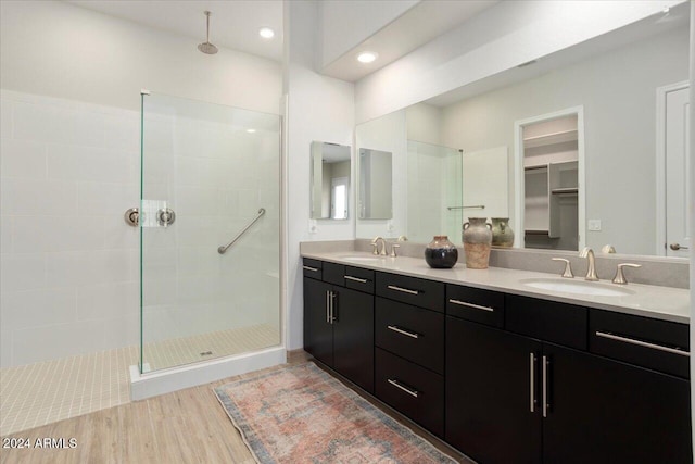 bathroom featuring hardwood / wood-style floors, vanity, and tiled shower