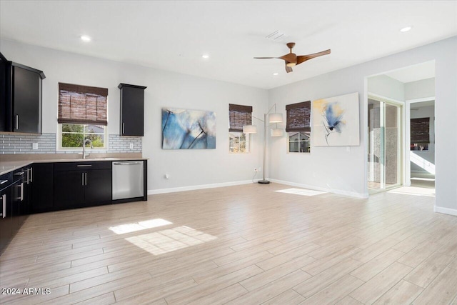 kitchen featuring stainless steel dishwasher, ceiling fan, light wood-type flooring, and backsplash