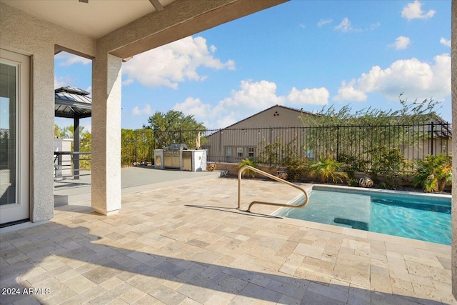 view of swimming pool featuring a patio and an outdoor kitchen