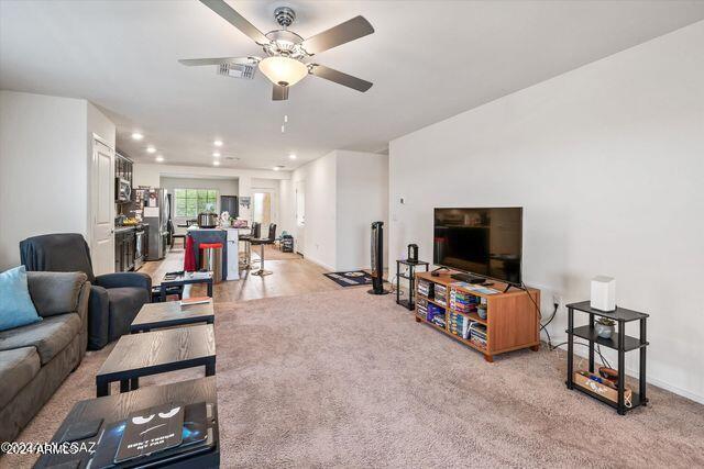 carpeted living room featuring ceiling fan