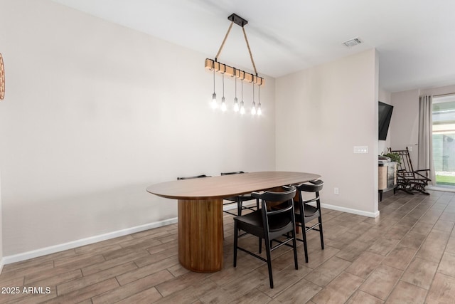dining area featuring baseboards, visible vents, and light wood-type flooring