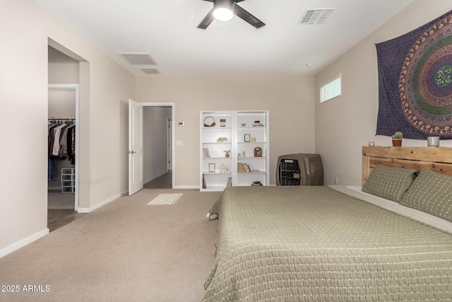 carpeted bedroom with visible vents, baseboards, and a spacious closet