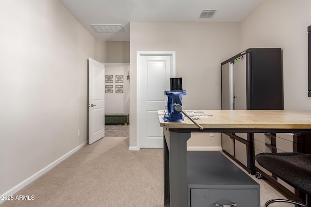 office featuring baseboards, light carpet, and visible vents