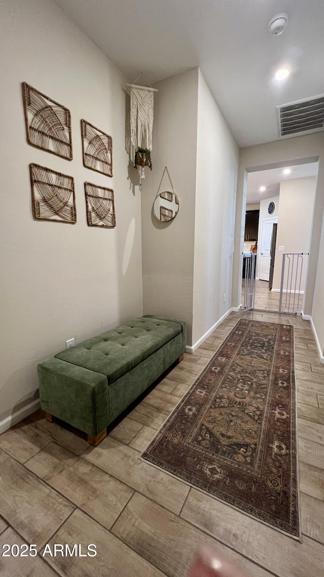 hallway featuring visible vents, recessed lighting, baseboards, and wood finished floors