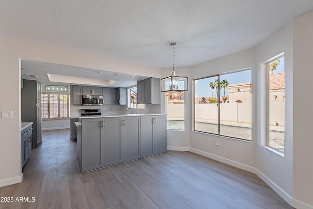 16609 S 41st St, Phoenix, AZ 85048 - kitchen with gray cabinetry, stainless steel microwave, wood finished floors, a peninsula, and light countertops