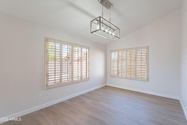 16609 S 41st St, Phoenix, AZ 85048 - empty room featuring wood finished floors, vaulted ceiling, and a chandelier