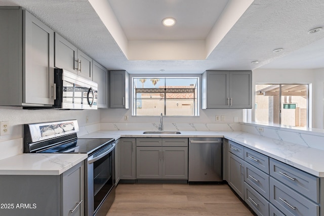 16609 S 41st St, Phoenix, AZ 85048 - kitchen with stainless steel appliances, gray cabinetry, light wood-style floors, light stone countertops, and recessed lighting