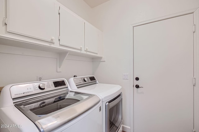 washroom featuring washing machine and dryer and cabinets