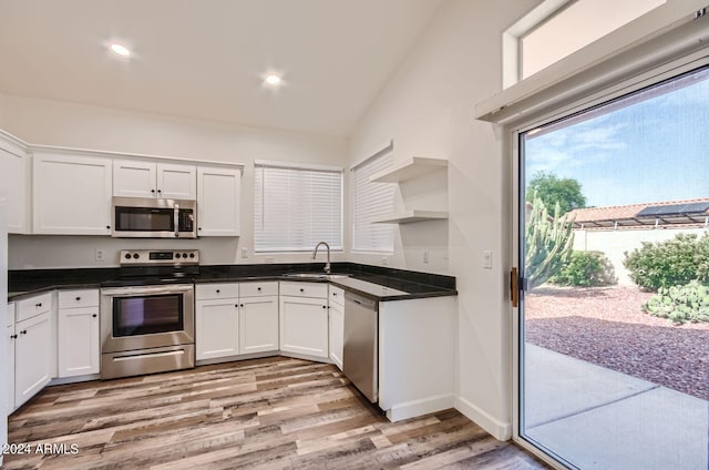 kitchen featuring sink, light wood-type flooring, white cabinets, and appliances with stainless steel finishes