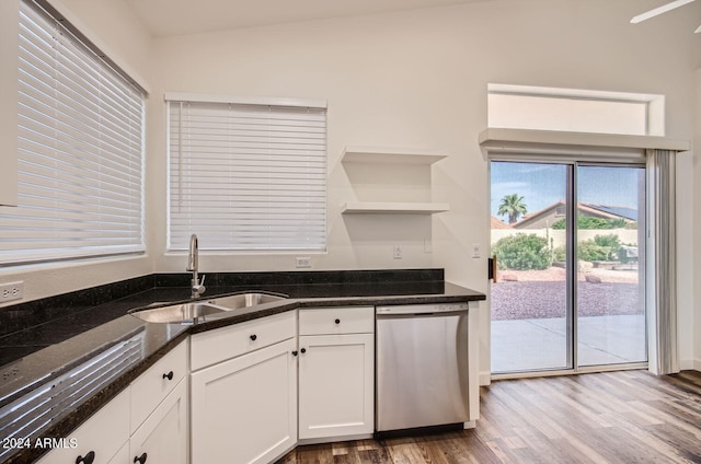 kitchen featuring sink, white cabinetry, light hardwood / wood-style flooring, dishwasher, and dark stone counters