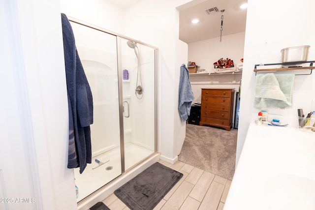 bathroom featuring vanity, visible vents, wood tiled floor, recessed lighting, and a shower stall