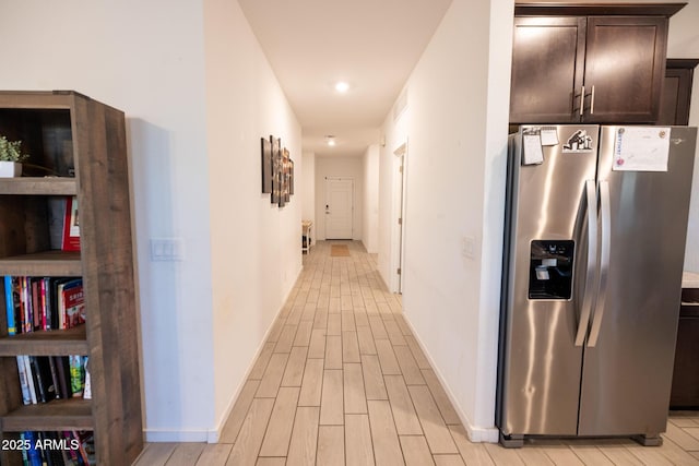 hall with visible vents, baseboards, and light wood-style floors