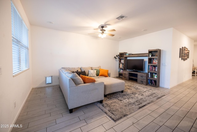 living area featuring ceiling fan, baseboards, visible vents, and wood finish floors